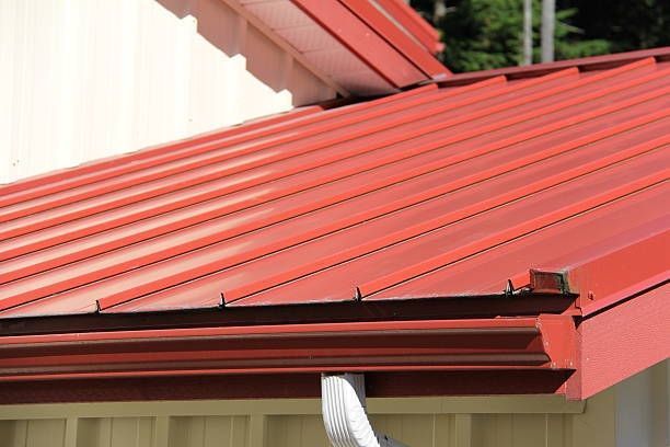 Red metal roof with matching gutters, on a building.