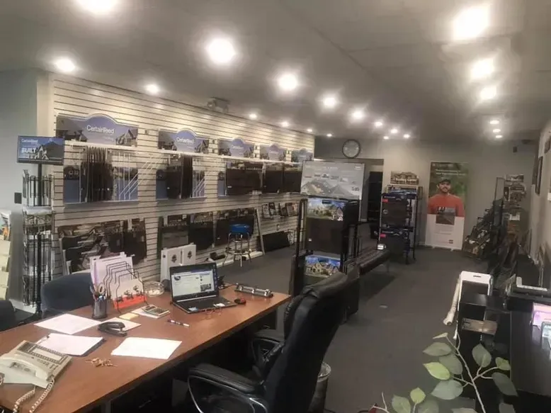 Interior of a store with products displayed on shelves and a desk with a laptop and phone.