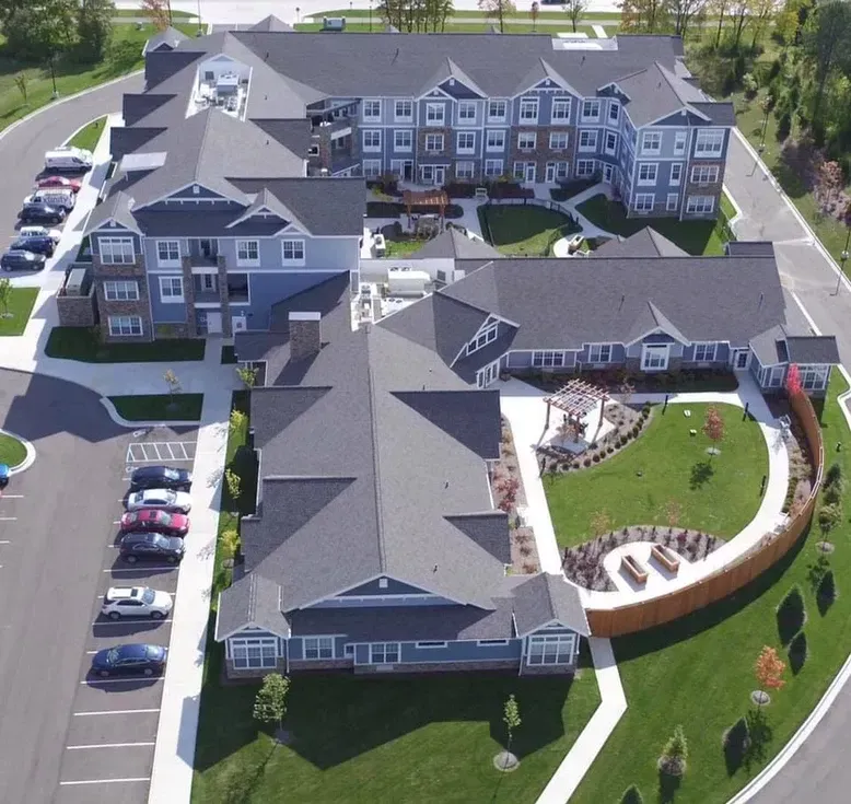 Aerial view of a senior living facility with multiple buildings, courtyards, and parking.