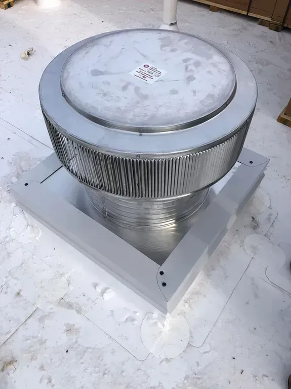 Rooftop ventilation unit with cylindrical fan encased in a metal shroud.