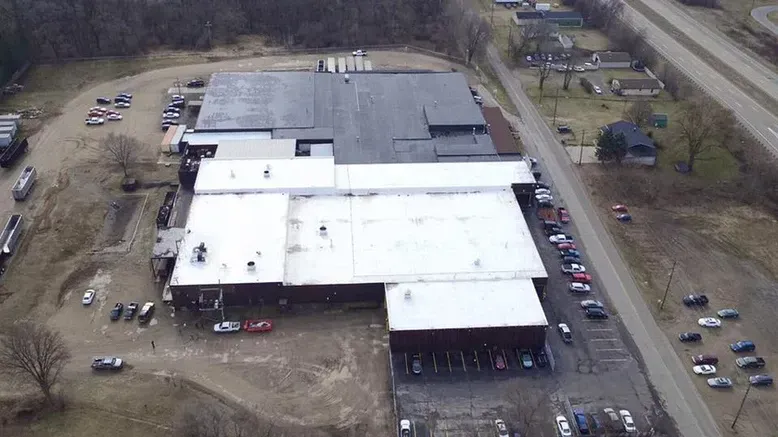 Aerial view of a large industrial building with a dark roof.