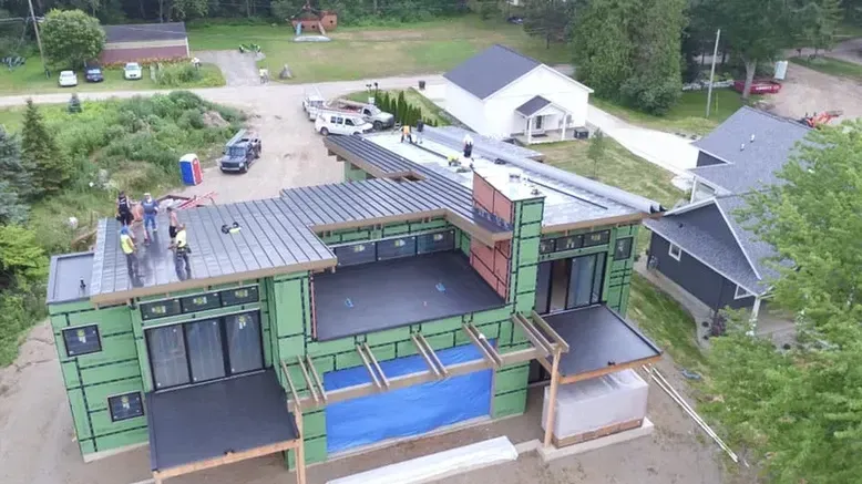 Construction site: workers on a modern, flat-roofed house. 