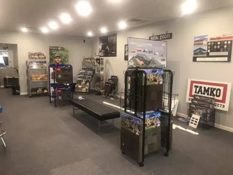 Interior of a store displays shelving with merchandise, posters, and a bench.