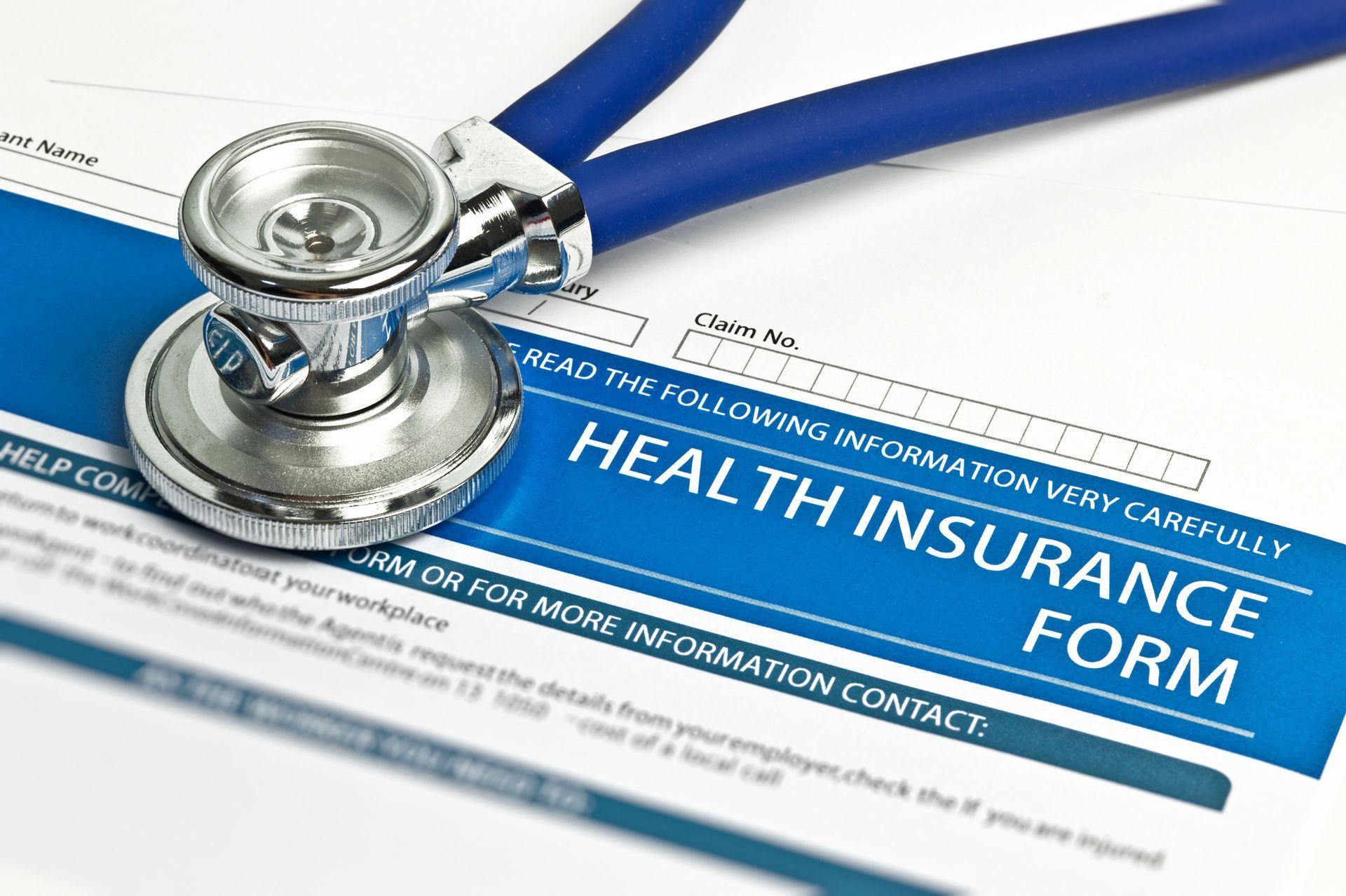 A blue stethoscope rests on a health insurance form.