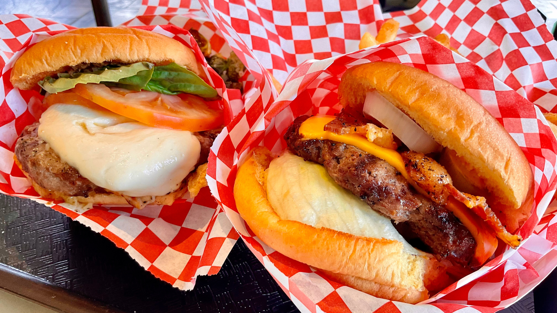 Two mouthwatering burgers featuring juicy beef patties, melted cheese, fresh lettuce, tomatoes.