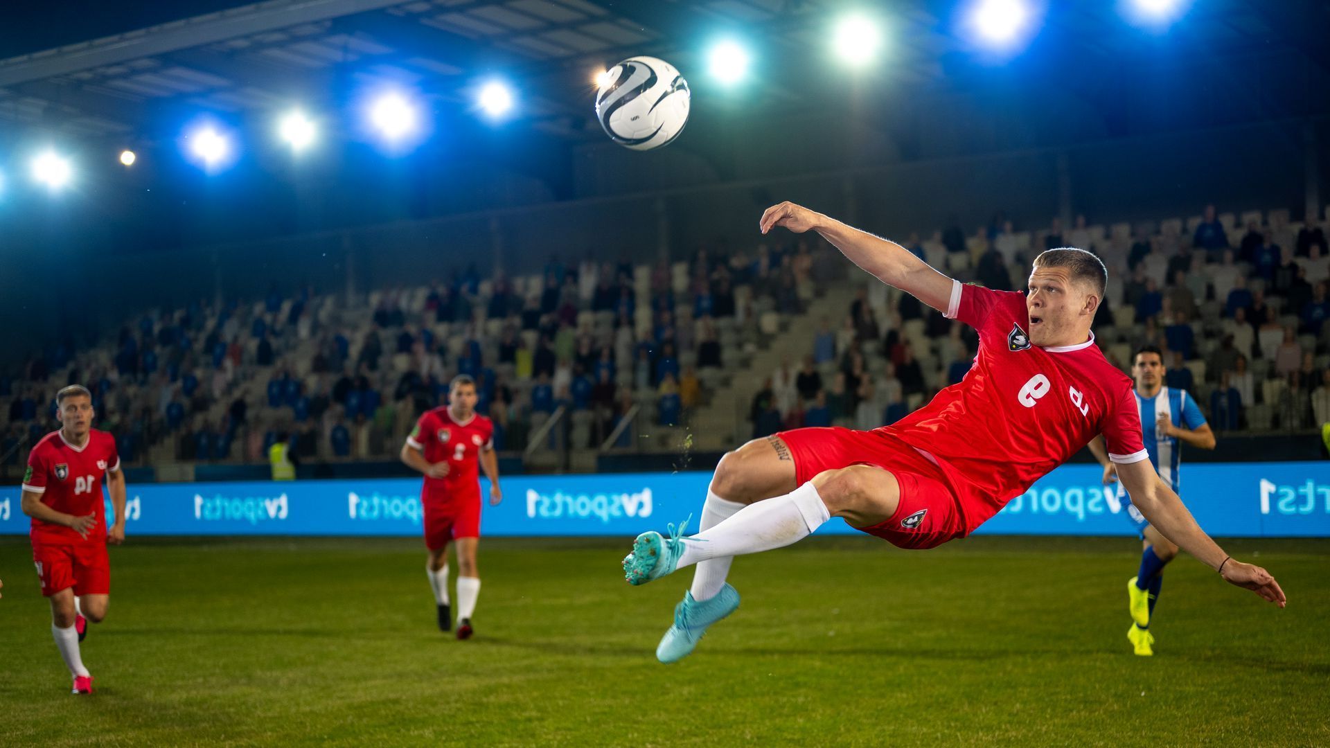 A soccer player is jumping in the air to head the ball during a game.