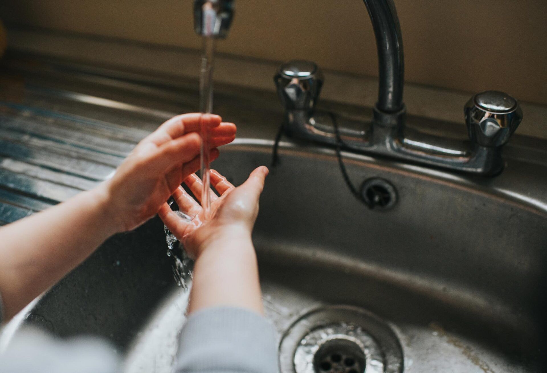 Kid Washing Hands Under A Tap — Houston, TX — Richter’s Services Inc.