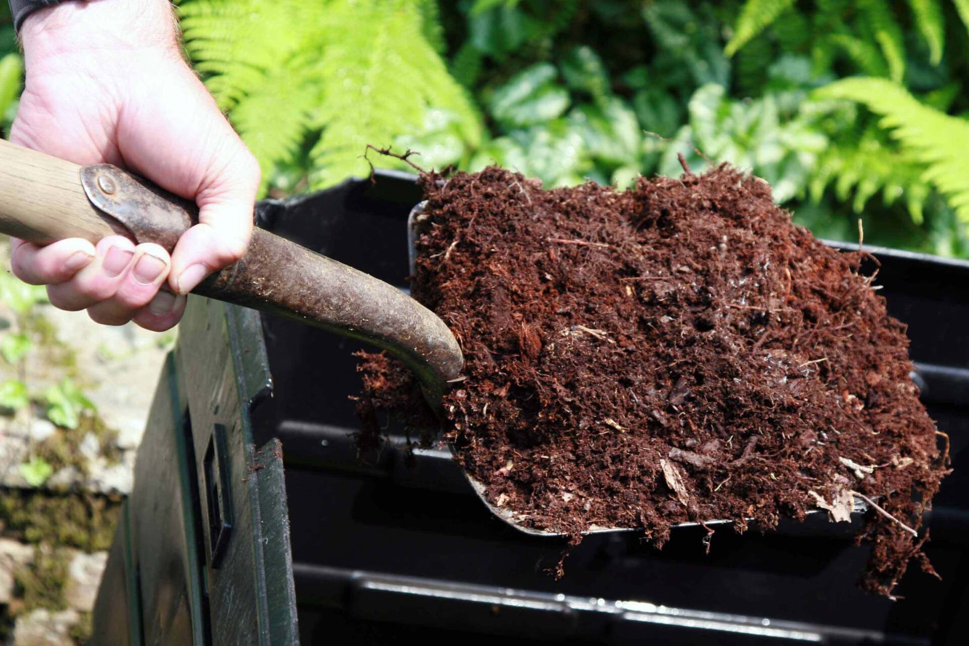 Hand Holding Shovel Full Of Compost — Houston, TX — Richter’s Services Inc.