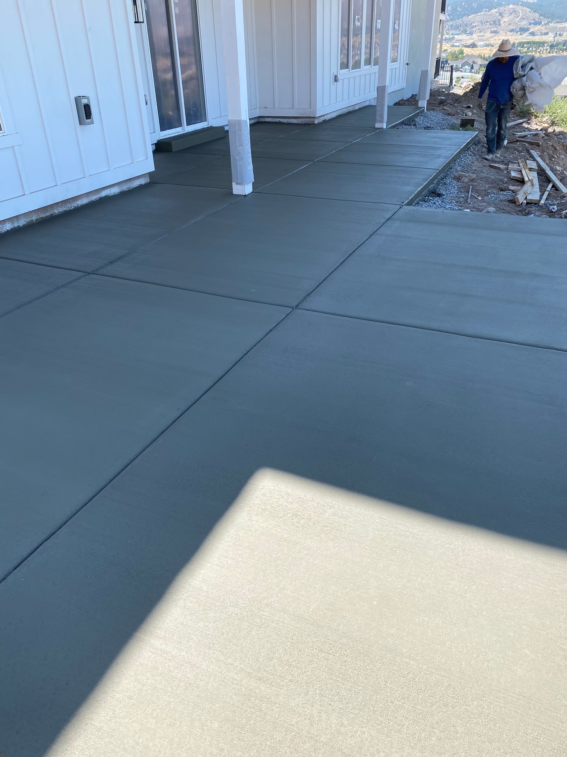 Newly poured concrete driveway with a person walking towards the end.