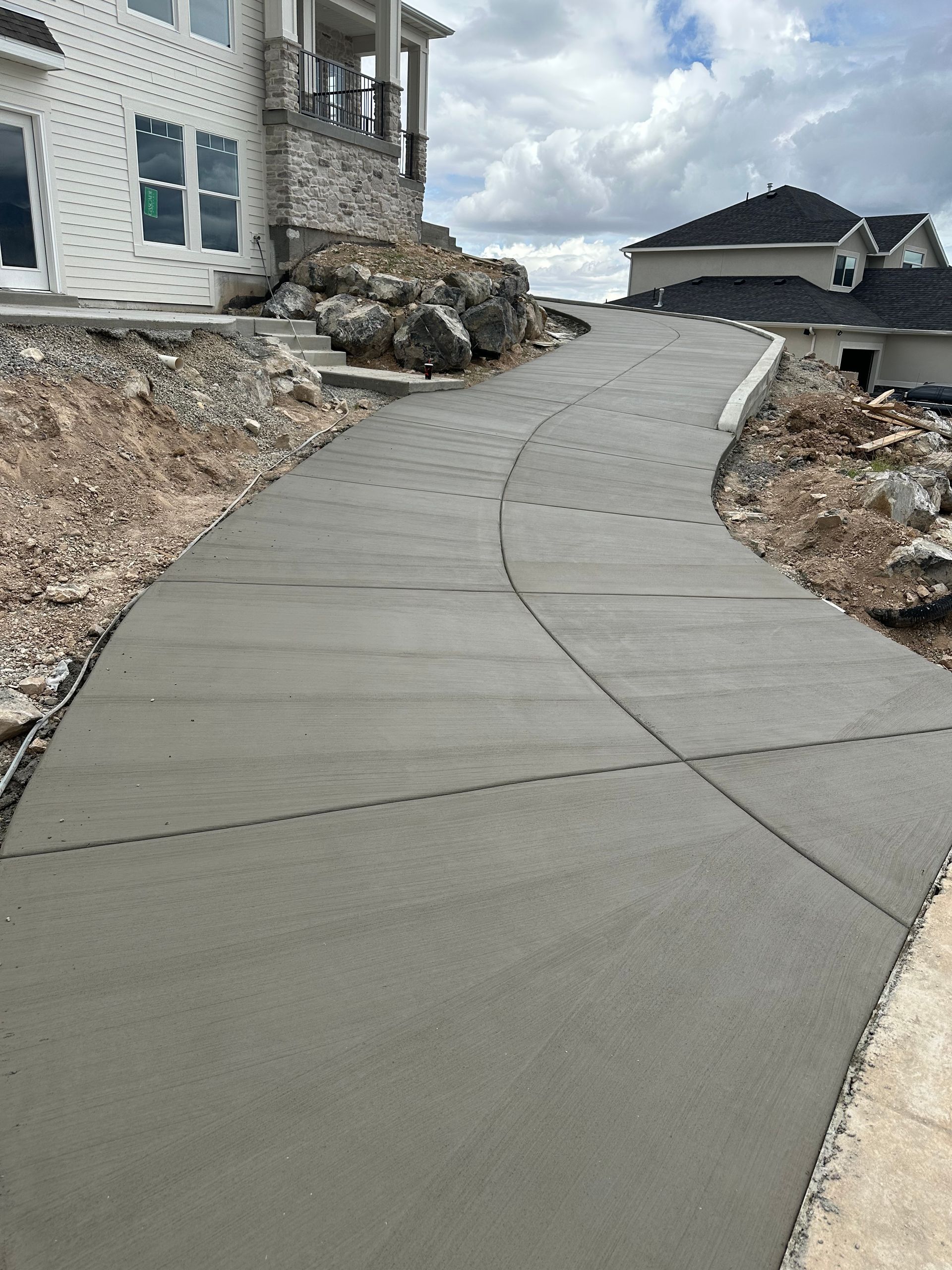 New concrete walkway leading up to a house under construction.