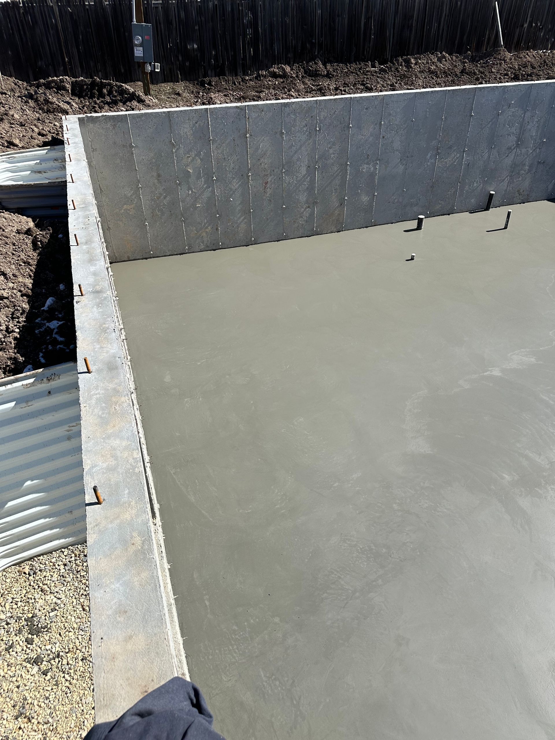 Concrete slab poured inside concrete retaining walls, outdoors.