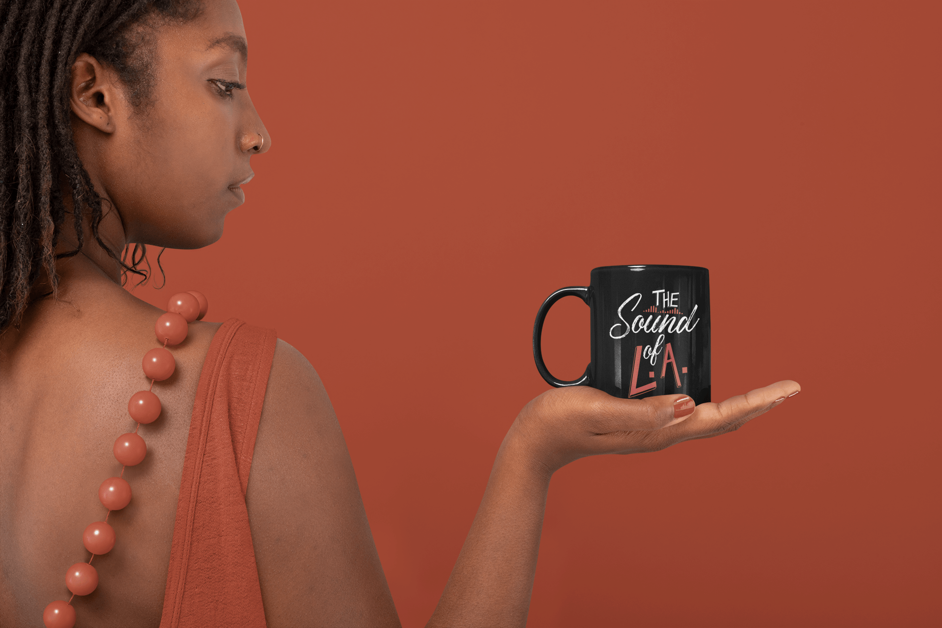 A woman is holding a coffee mug in her hand.