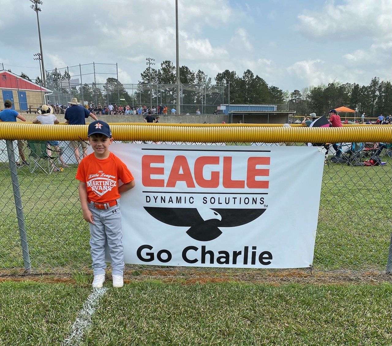 A young boy stands in front of an eagle dynamic solutions sign
