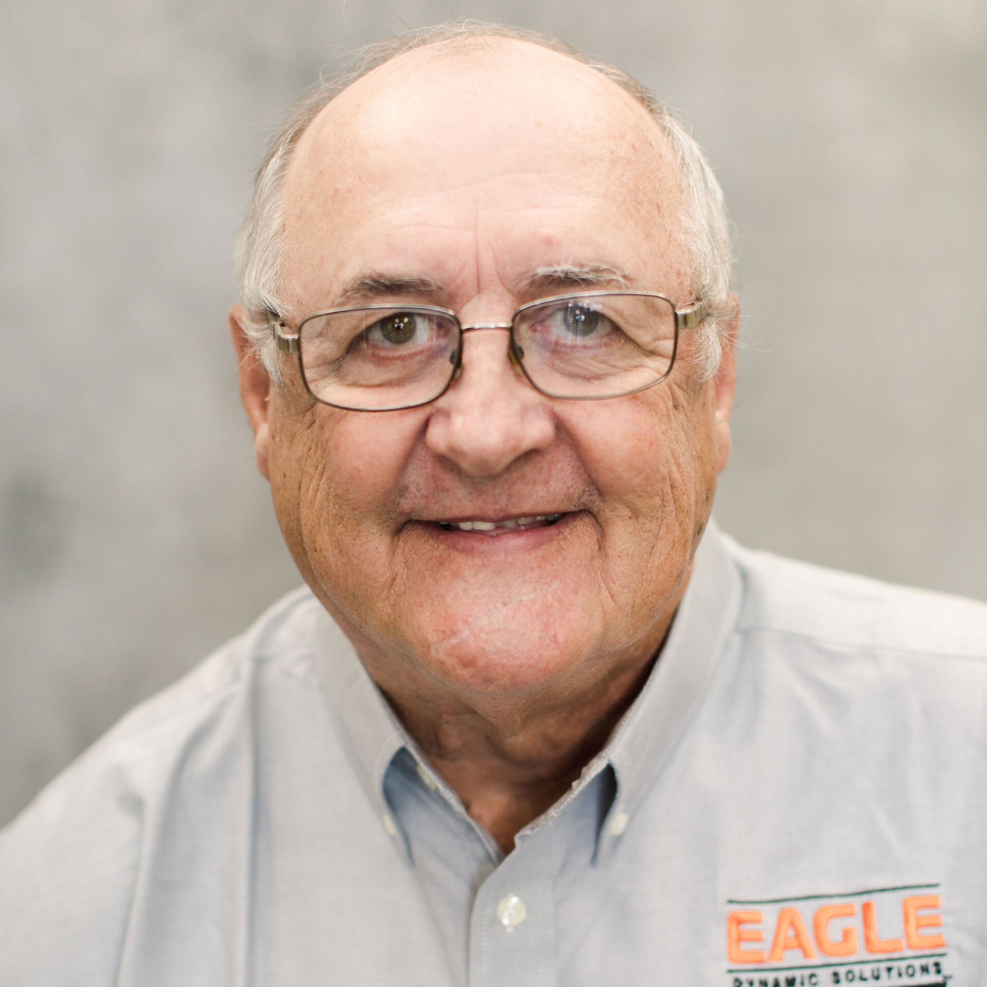 A man wearing glasses and a shirt that says eagle