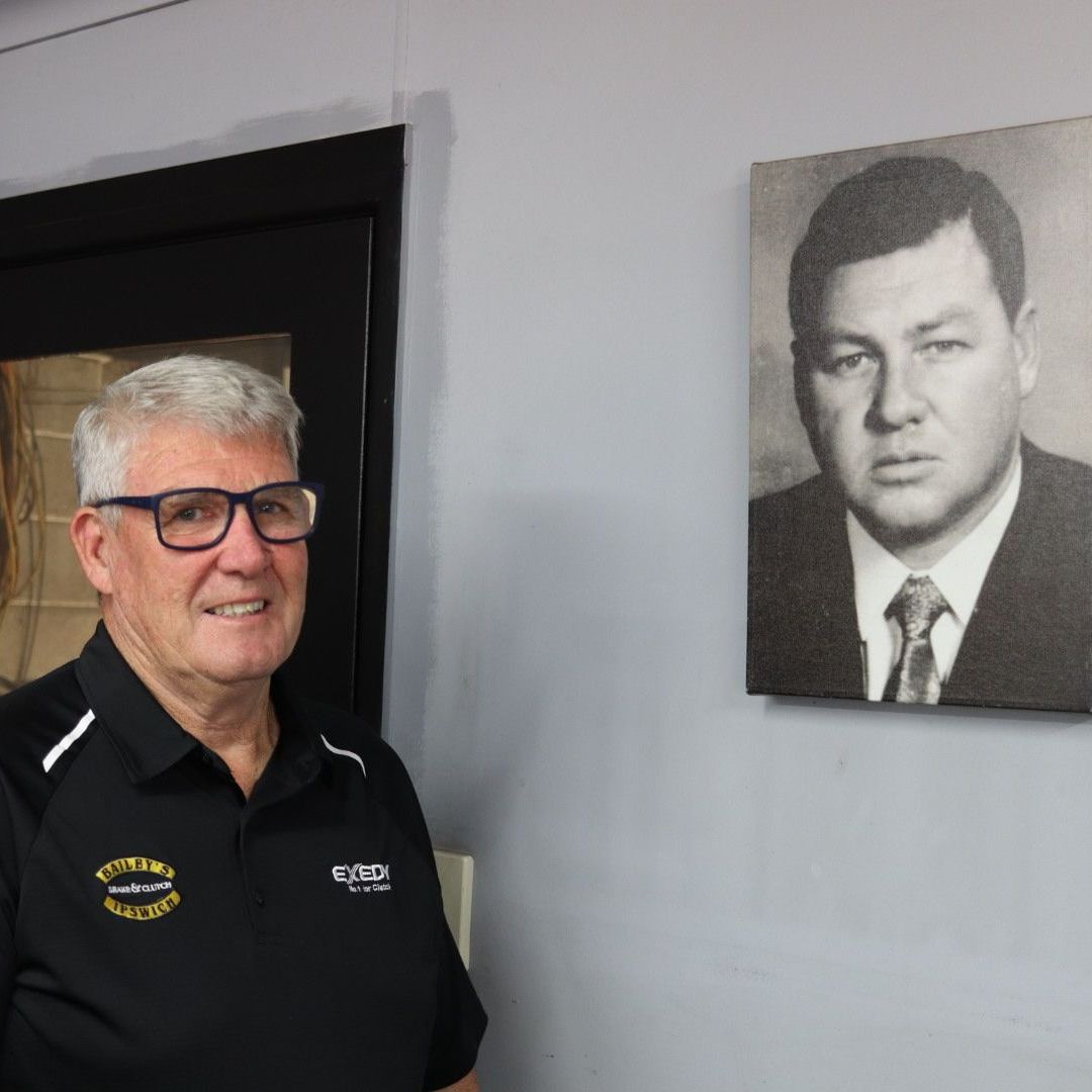 a man is standing in front of a painting of a man in a suit and tie .