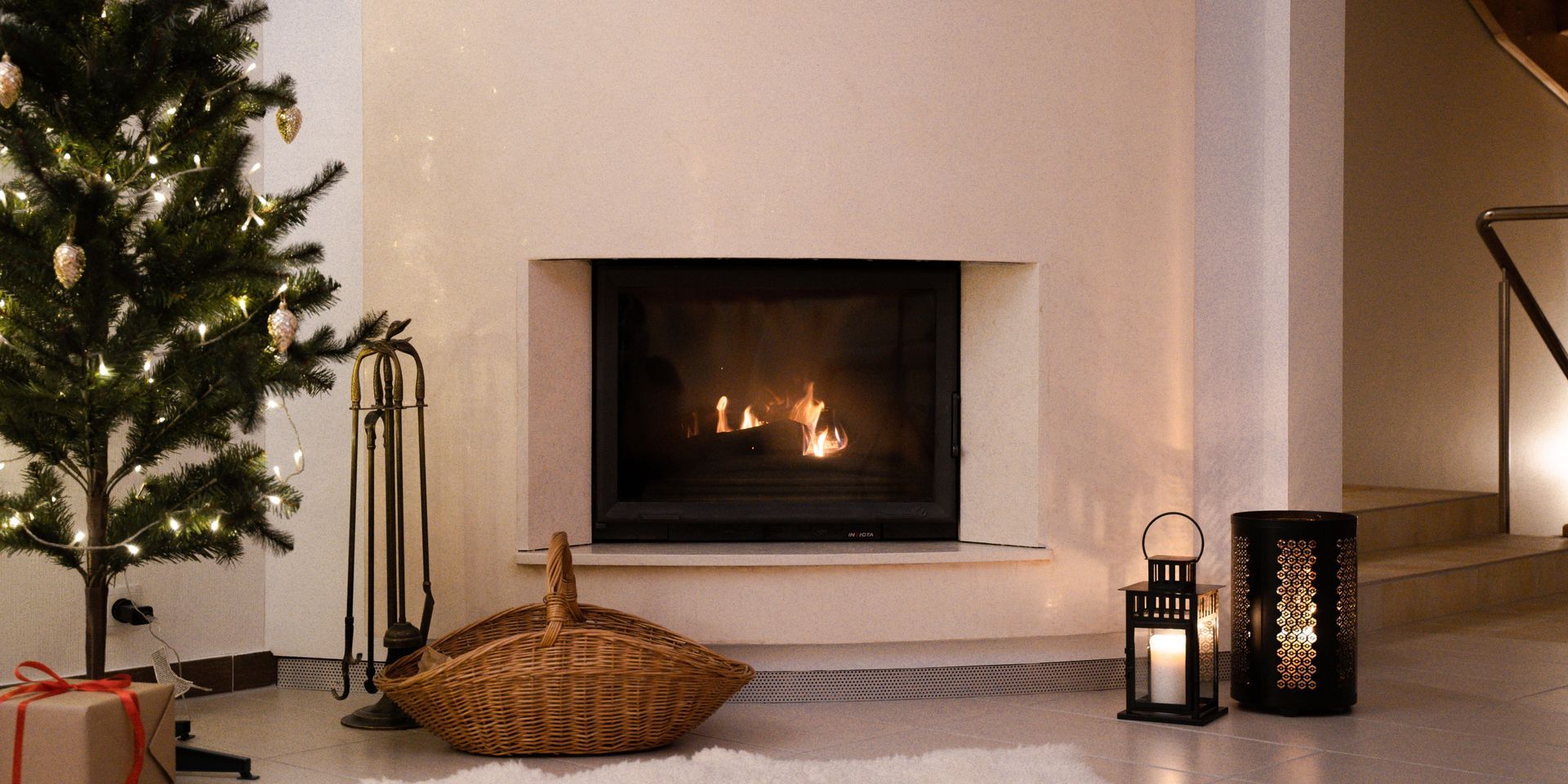 Cozy Christmas scene with fireplace, tree, candles, and gift.