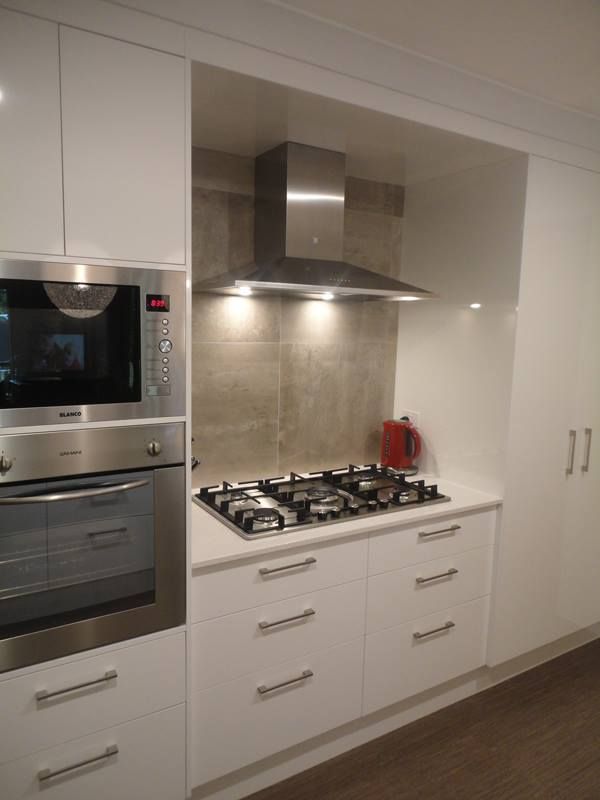 A Modern Kitchen With White Cabinets — Kitchens Factory Direct in Port Macquarie, NSW