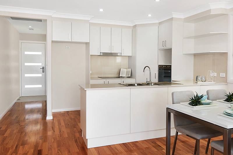 A Bright White Kitchen With Wooden Floors — Kitchens Factory Direct in Port Macquarie, NSW