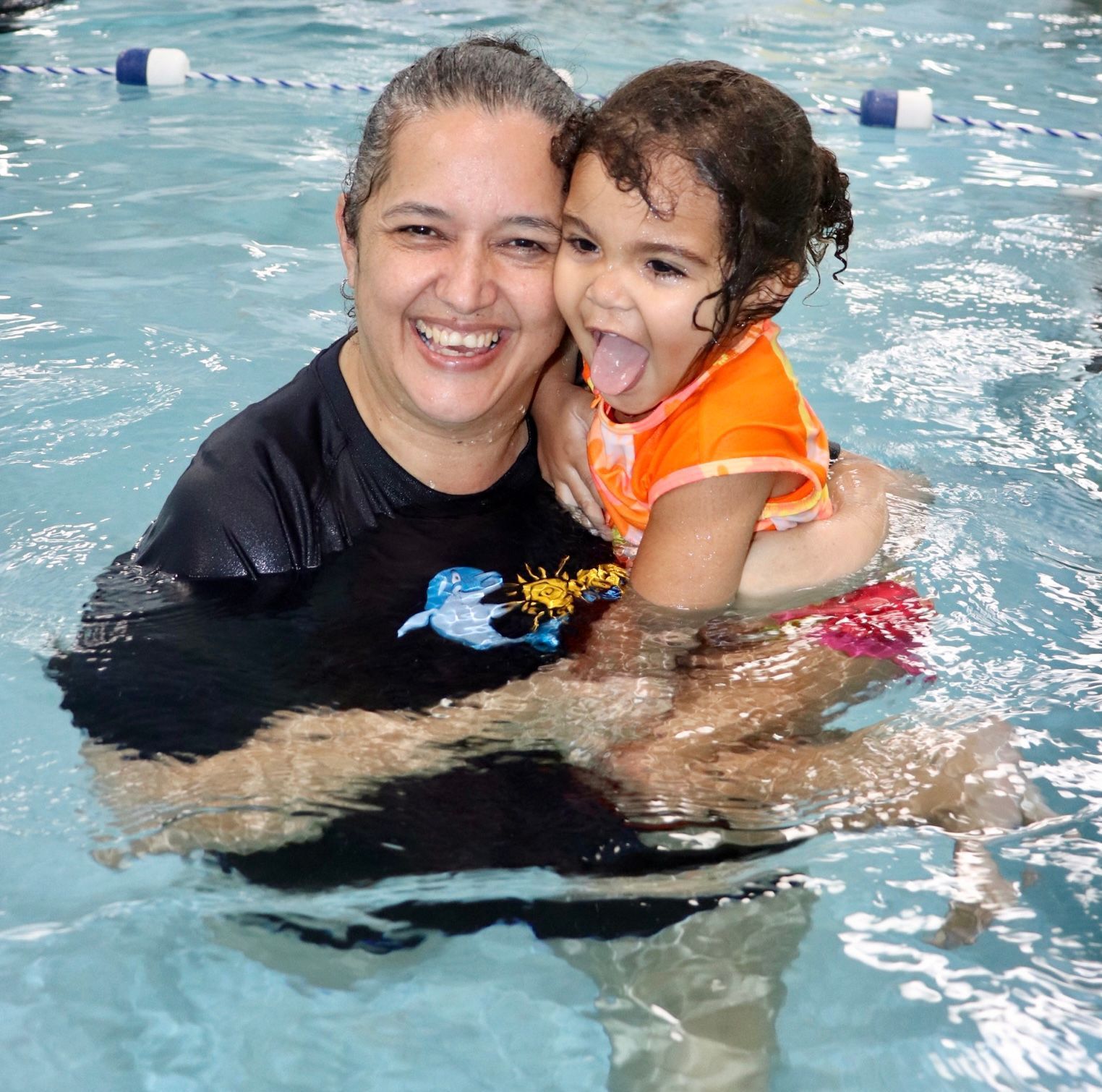Una mujer sostiene a una niña en una piscina por sus clases de natación en Ocaquatics