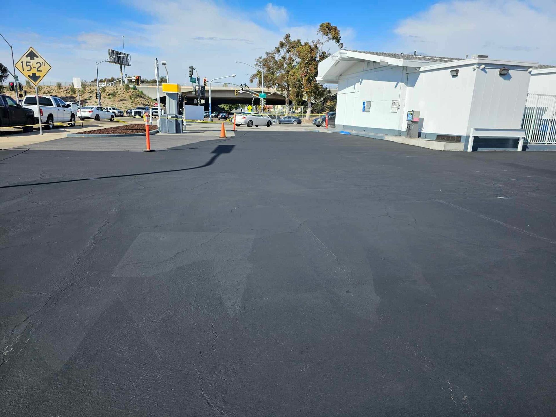 A black asphalt road with a white building in the background.