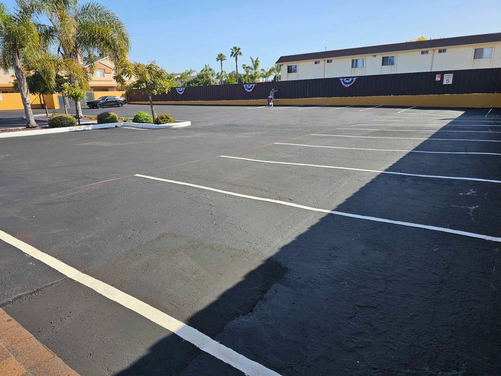 An empty parking lot with a building in the background