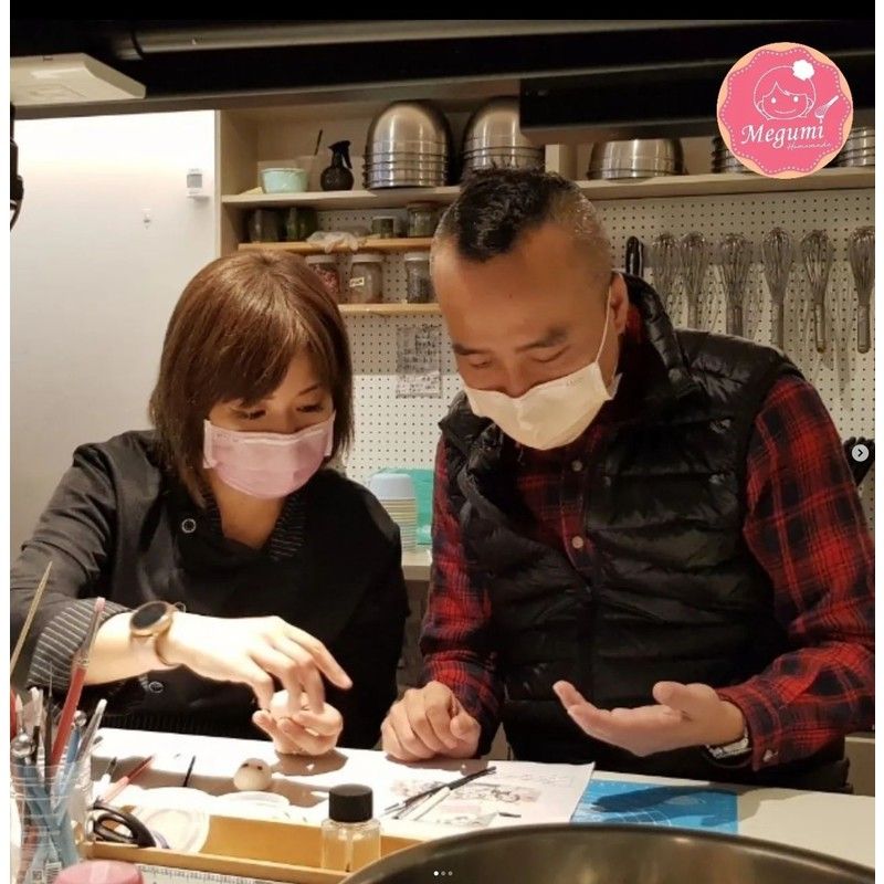 桌邊坐著一男一女戴著口罩