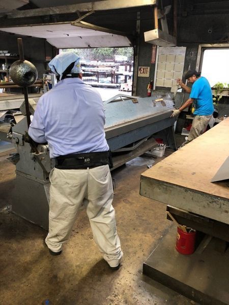 Two men are working on a machine in a factory.