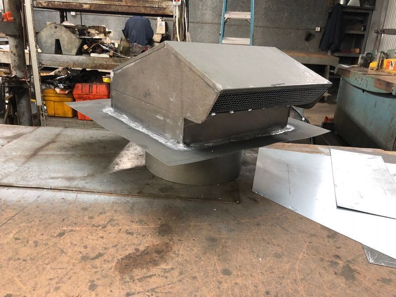 A metal item is sitting on a table in a factory.