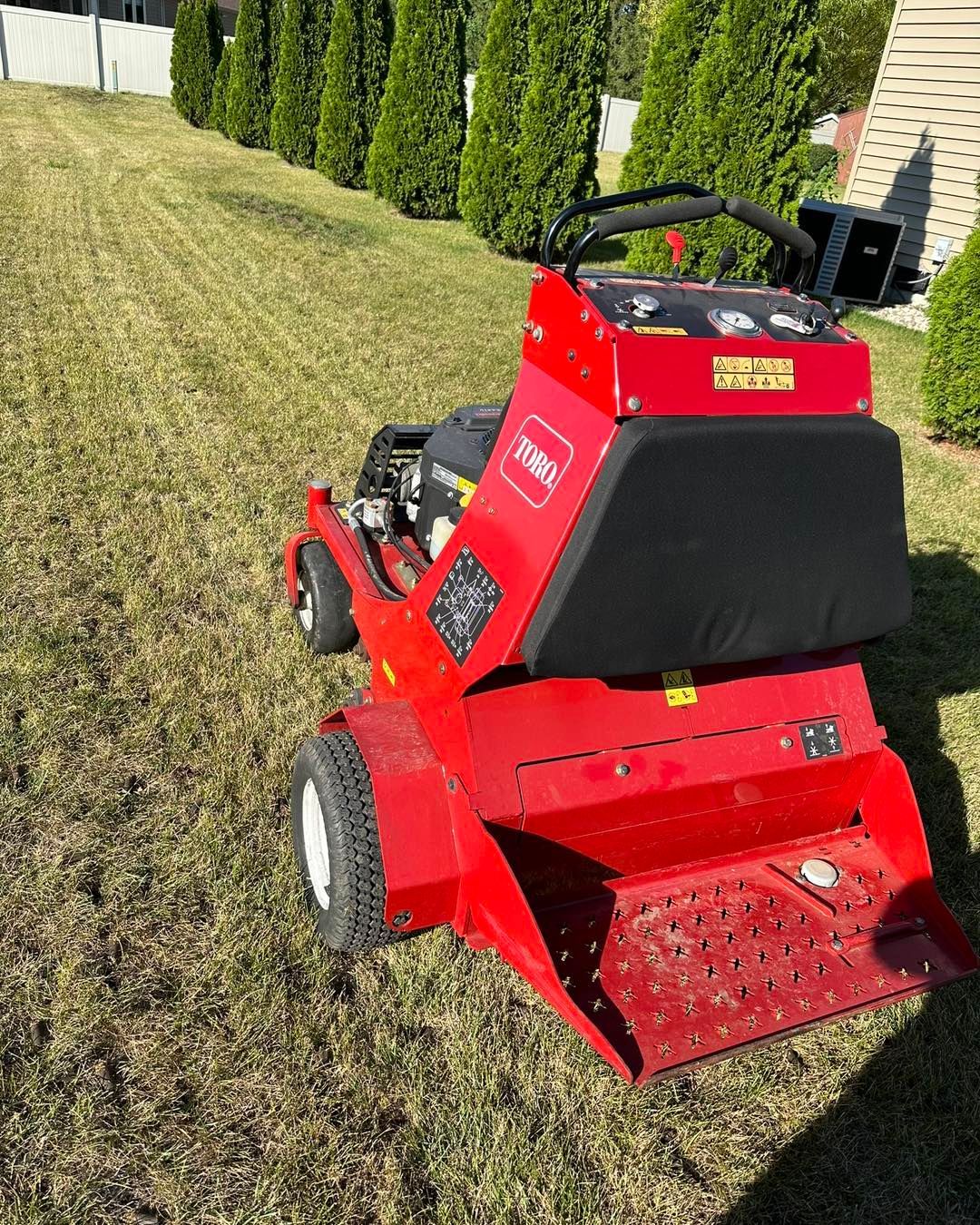 Red Toro commercial lawn aerator on a green lawn.