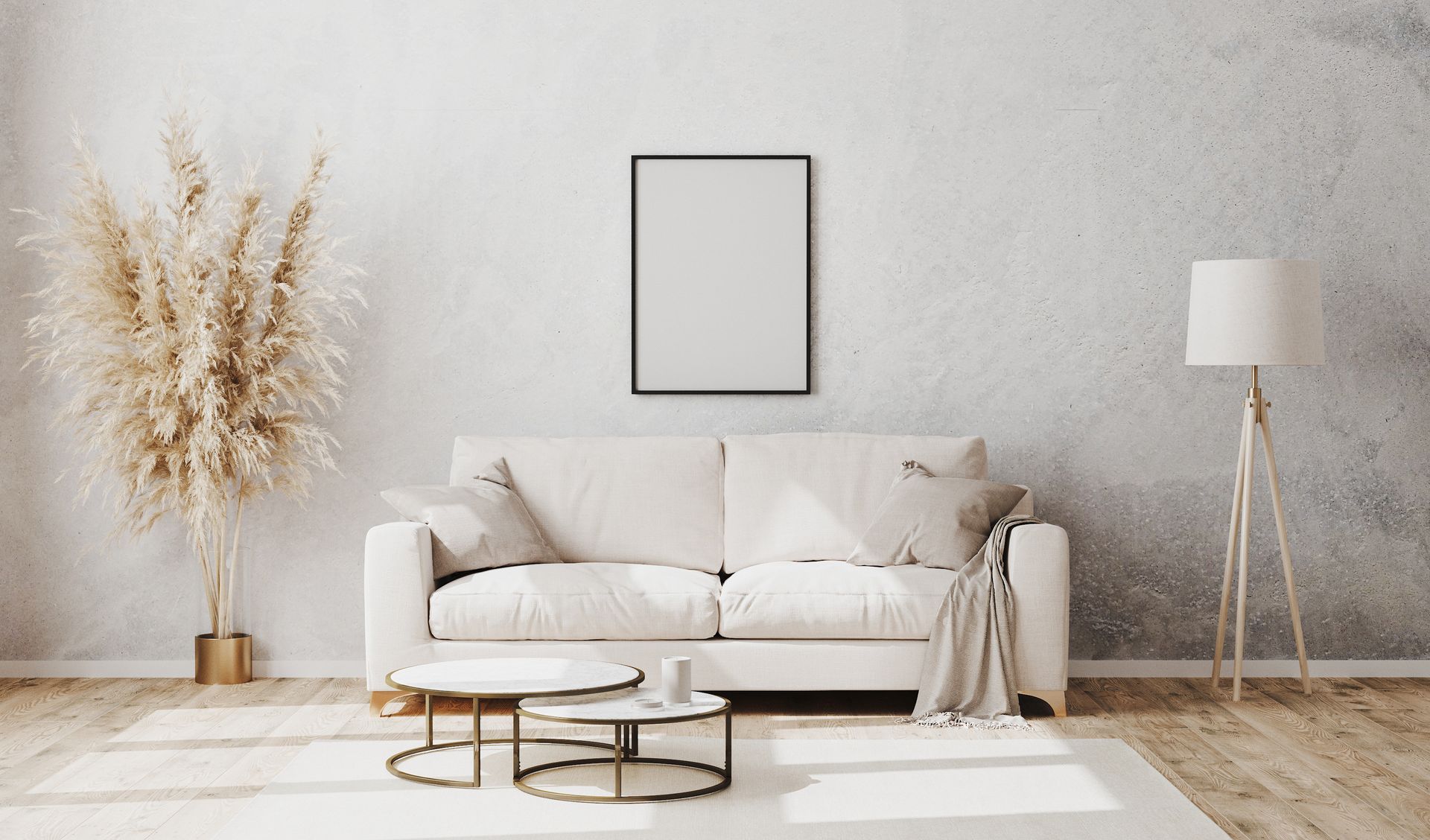 Ein minimalistisches Wohnzimmer mit einem weißen Sofa, einem schwarz gerahmten Kunstwerk an einer strukturierten Wand