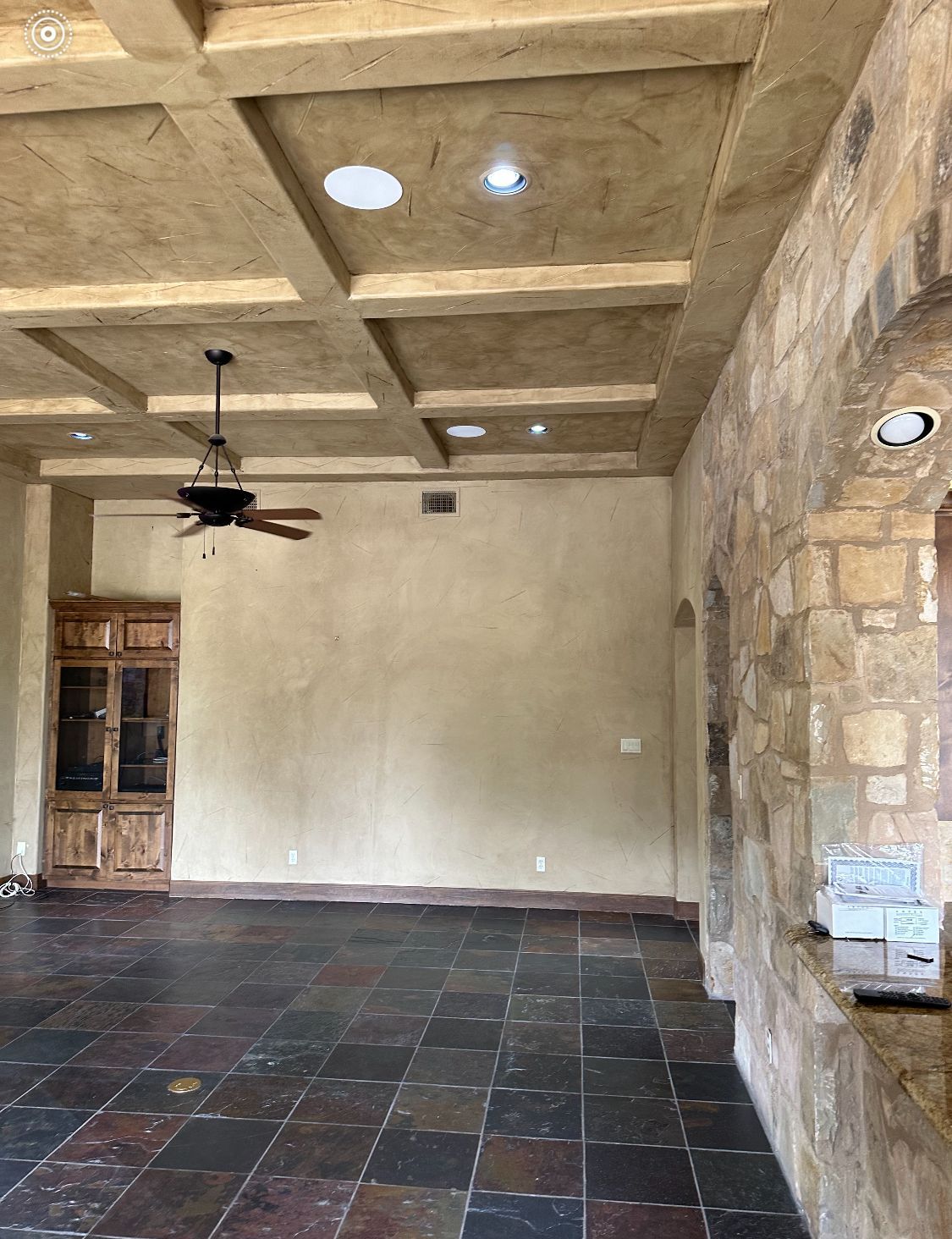An empty room with a ceiling fan and a tiled floor.