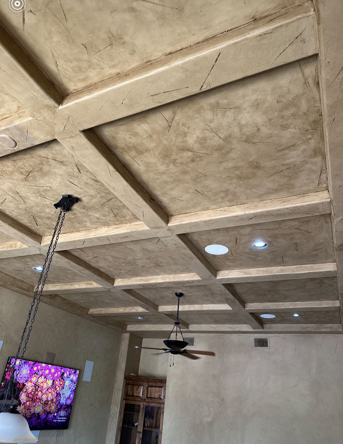A living room with a ceiling fan and a flat screen tv.