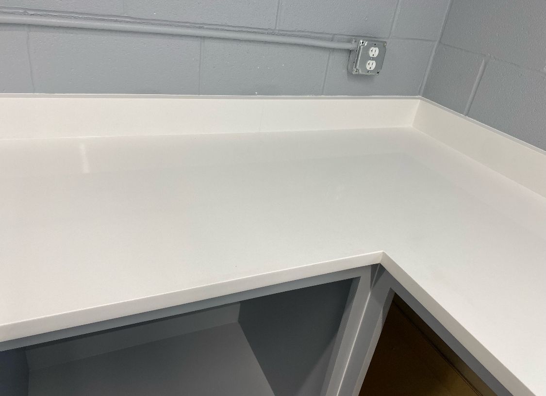 A white counter top with two electrical outlets on it
