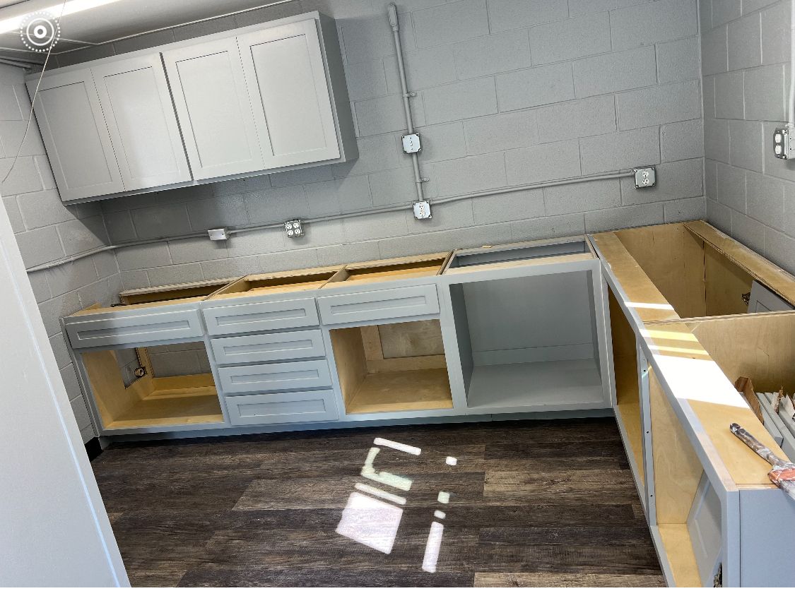 A kitchen with a sink and cabinets is being remodeled.