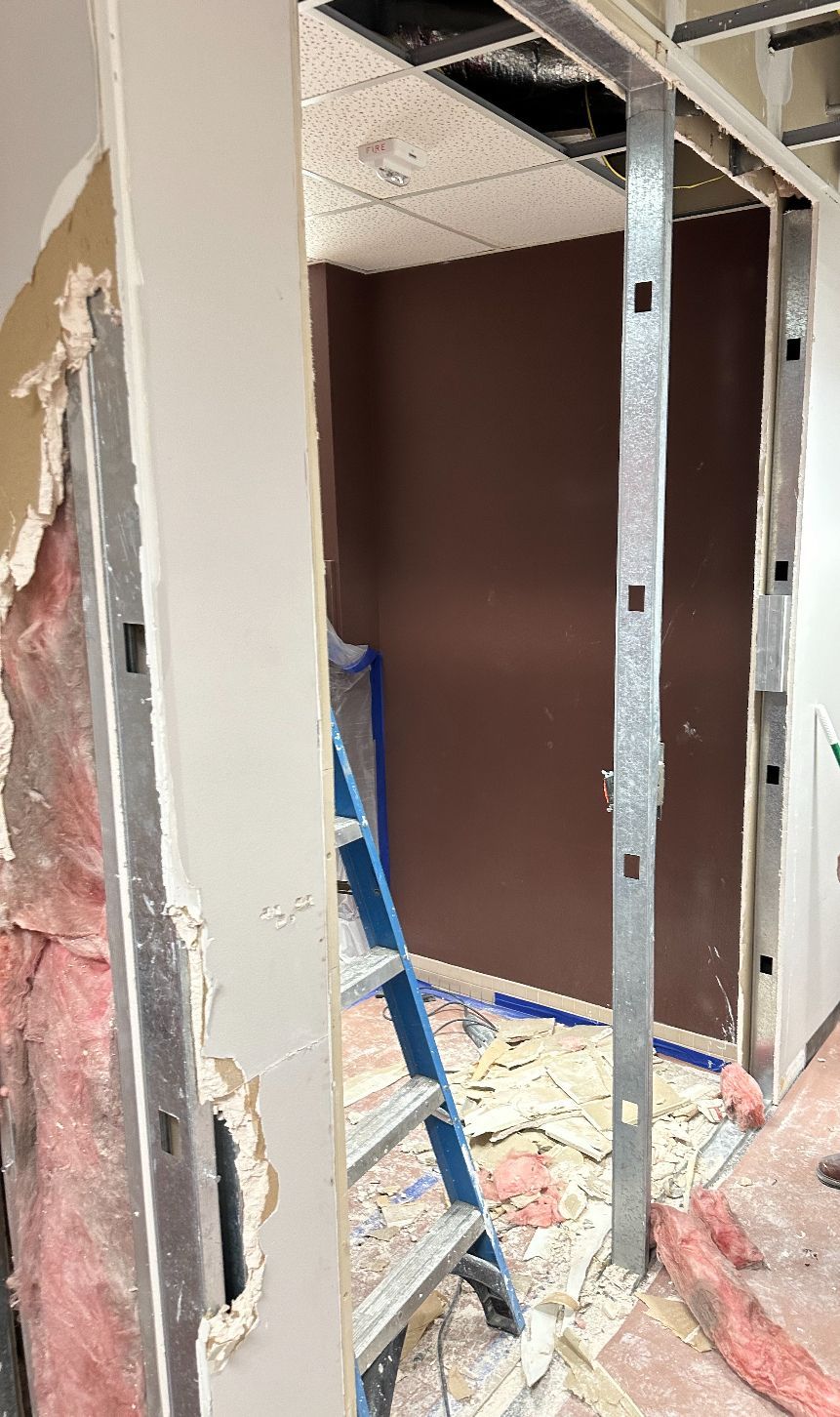 A room with a ladder in it and a hole in the wall.