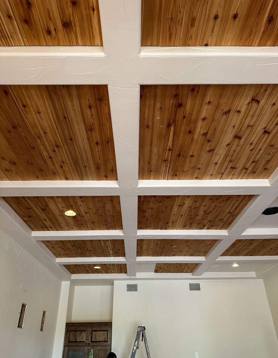 A room with a wooden ceiling and white beams.