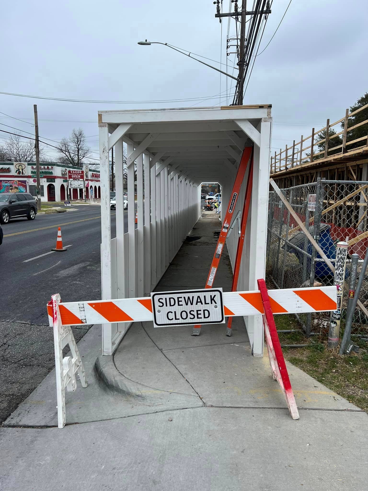 A safety pedestrian walkway with a sign that says sidewalk closed