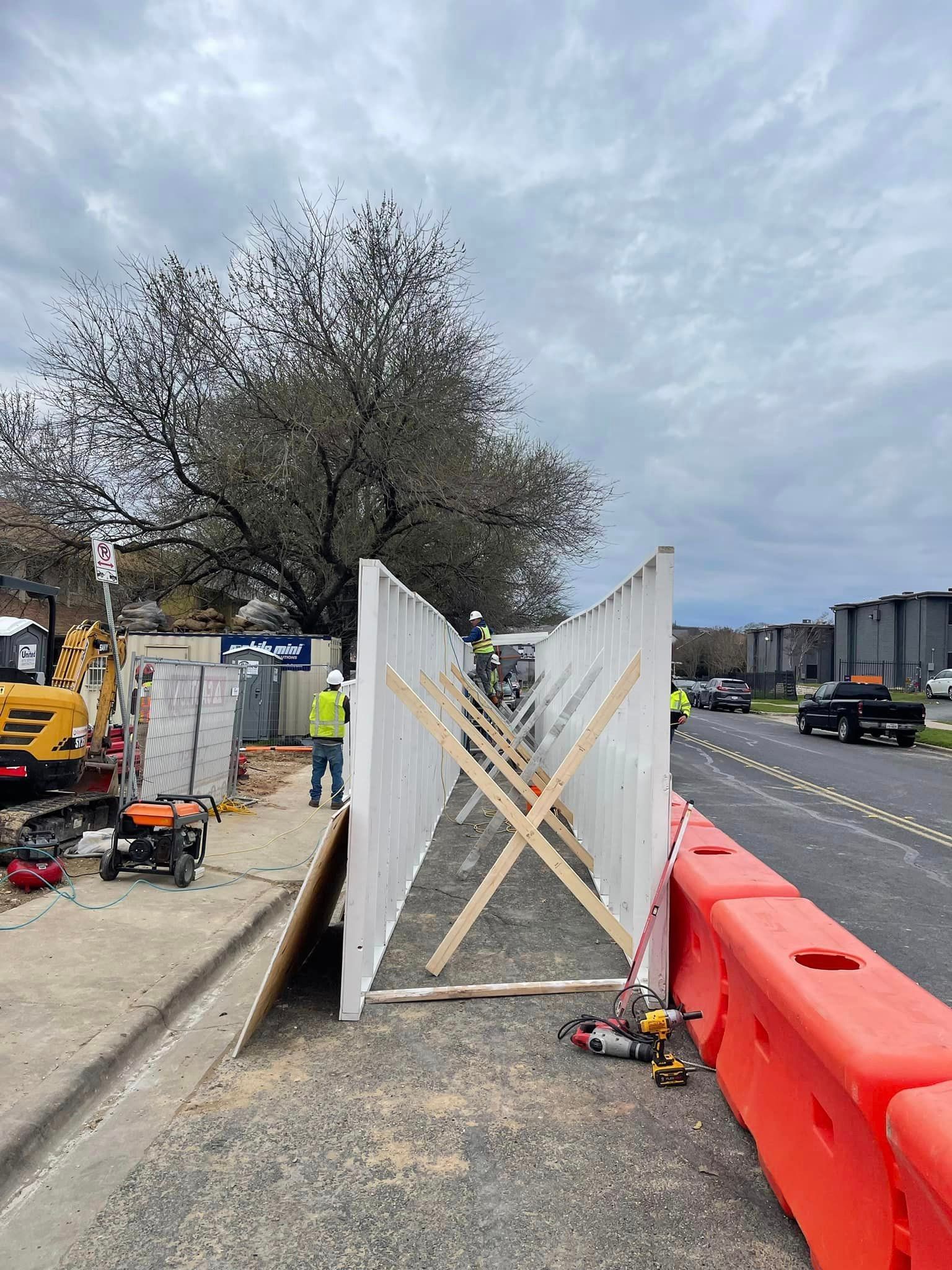 A construction site with a safety pedestrian walkway being built