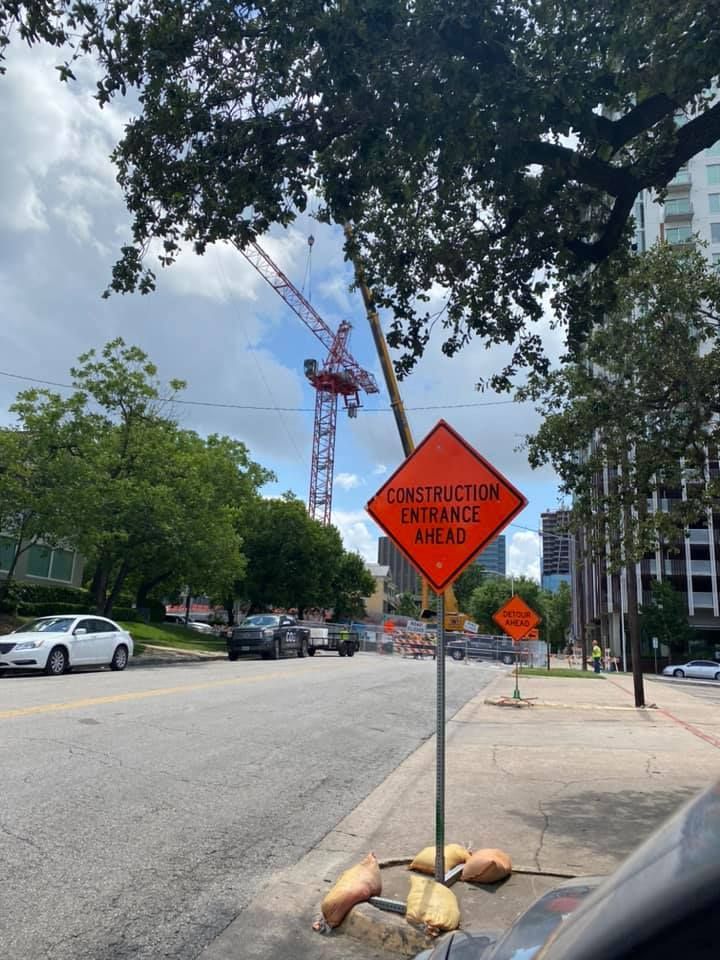A sign on the side of the road says construction entrance ahead