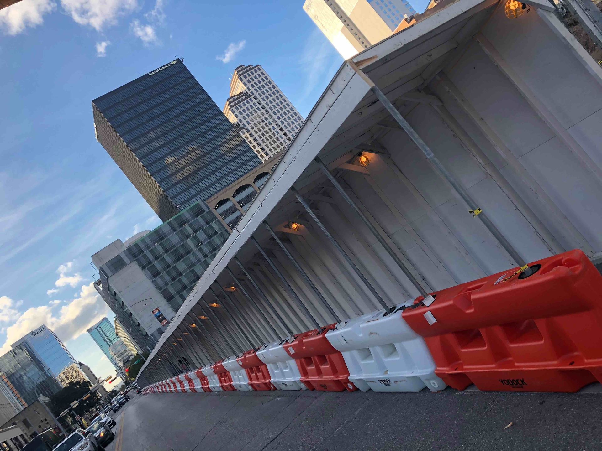 A row of water filled barriers are lined up in front of a building.