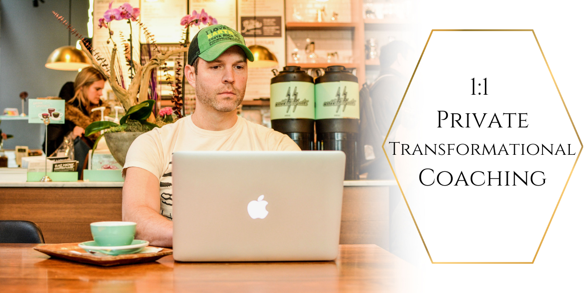 A man is sitting at a table using an apple laptop