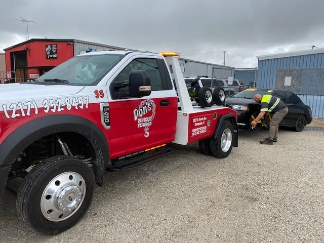 Man Towing A Black Car — Champaign, IL — Don’s 24 Hour Towing