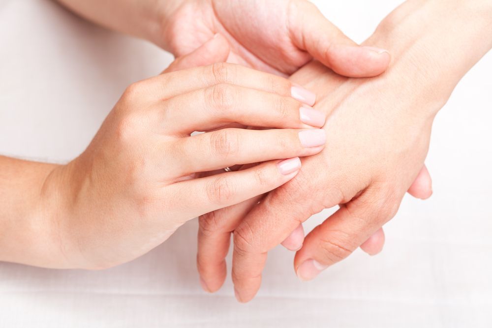 Person performing hand therapy on a client.