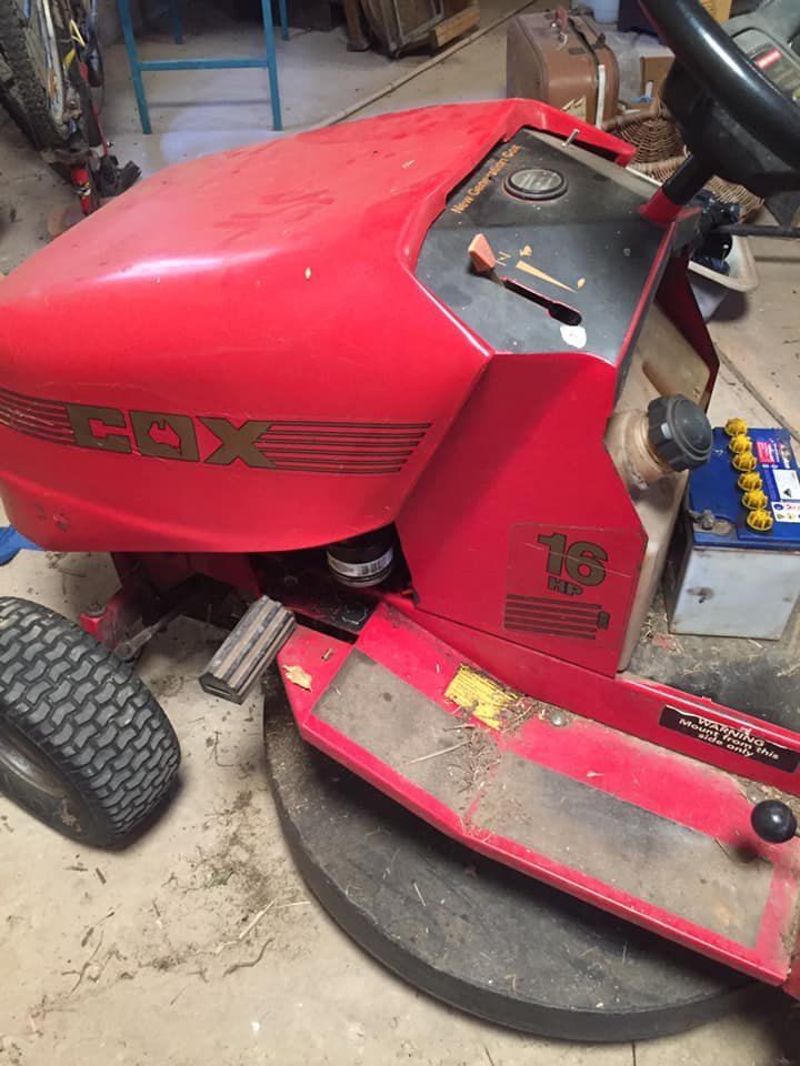 A Red Lawn Mower is Sitting on the Ground in a Garage — Coffs Coast Mobile Mechanical in Toormina, NSW