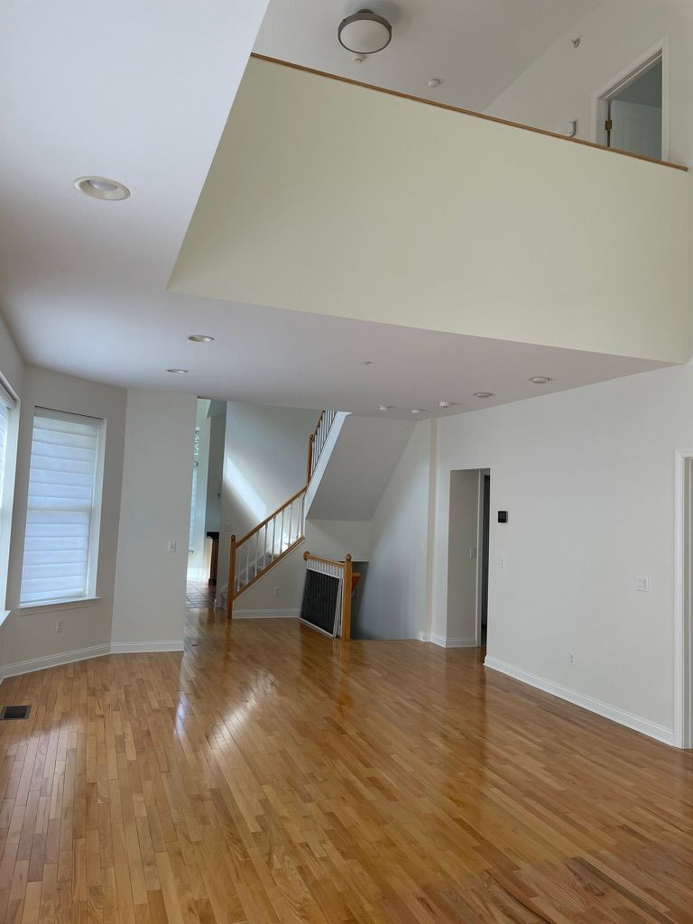 A man on a ladder paints the side of a house