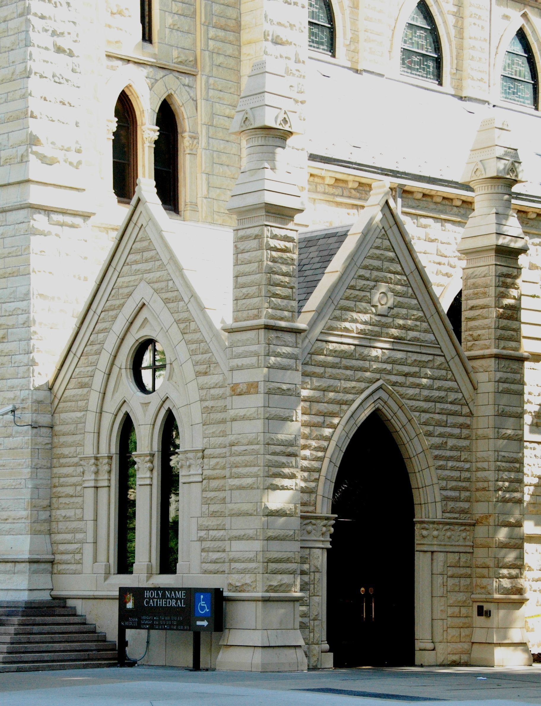 Stone building entrance with arched doorways and windows.