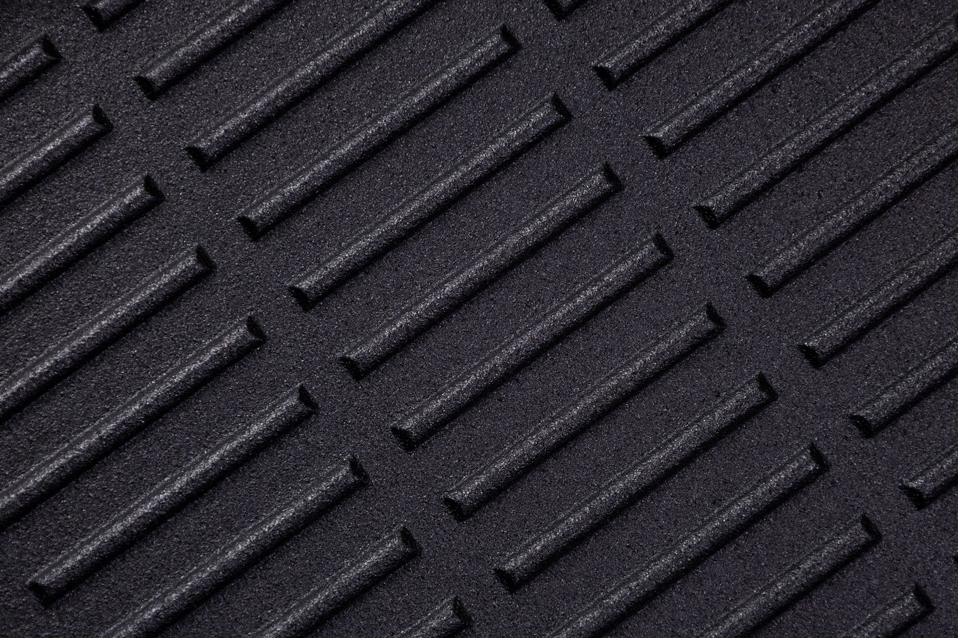 Surface pattern in a textured material showing lines and grooves created in a solid dark colour.