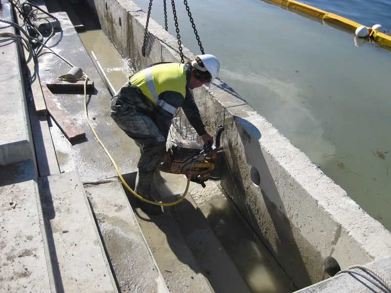 man using hand saw on concrete