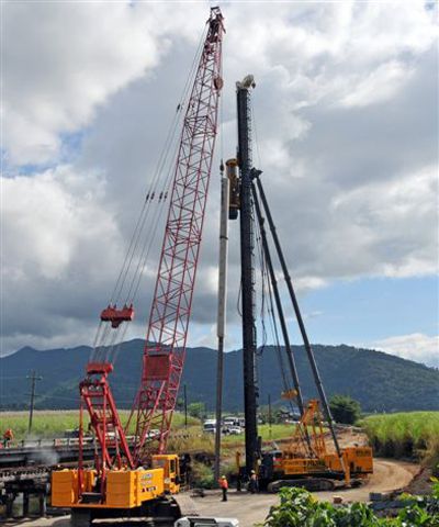 A Man Is Attaching A Chain To A Shipping Container — J & D Rigging Pty Ltd In Bohle, QLD