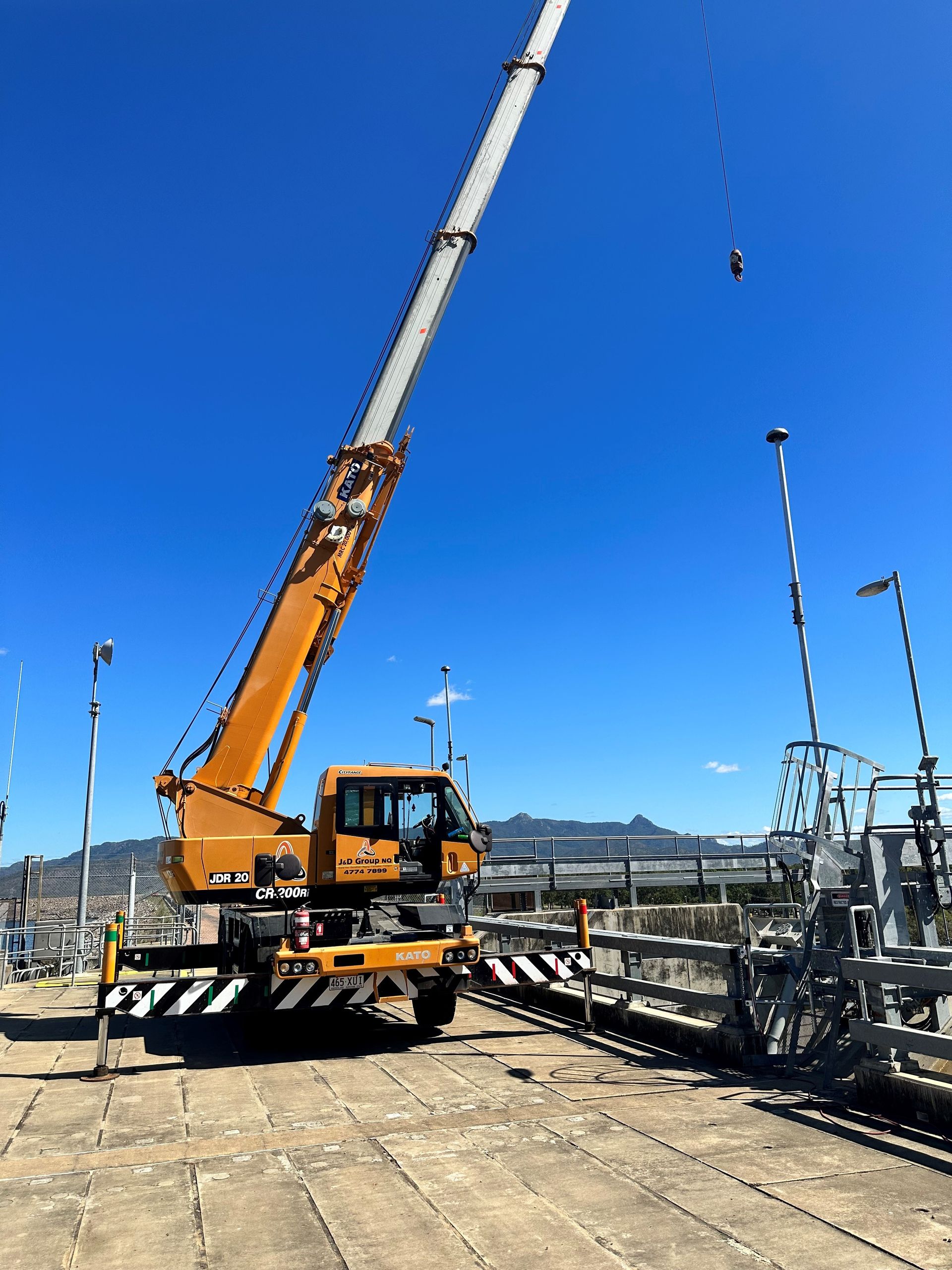 A Large Orange Crane Is Sitting On Top Of A Construction Site — J & D Rigging Pty Ltd In Bohle, QLD